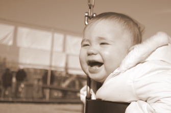 Domino, smiling, swinging on a swing.