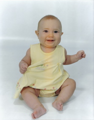 Domino, awake on stomach on white blanket