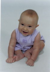 Domino, awake on stomach on white blanket