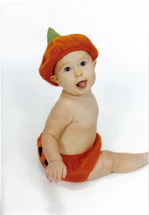 Domino, sitting, wearing pumpin bottoms and a pumpkin cap